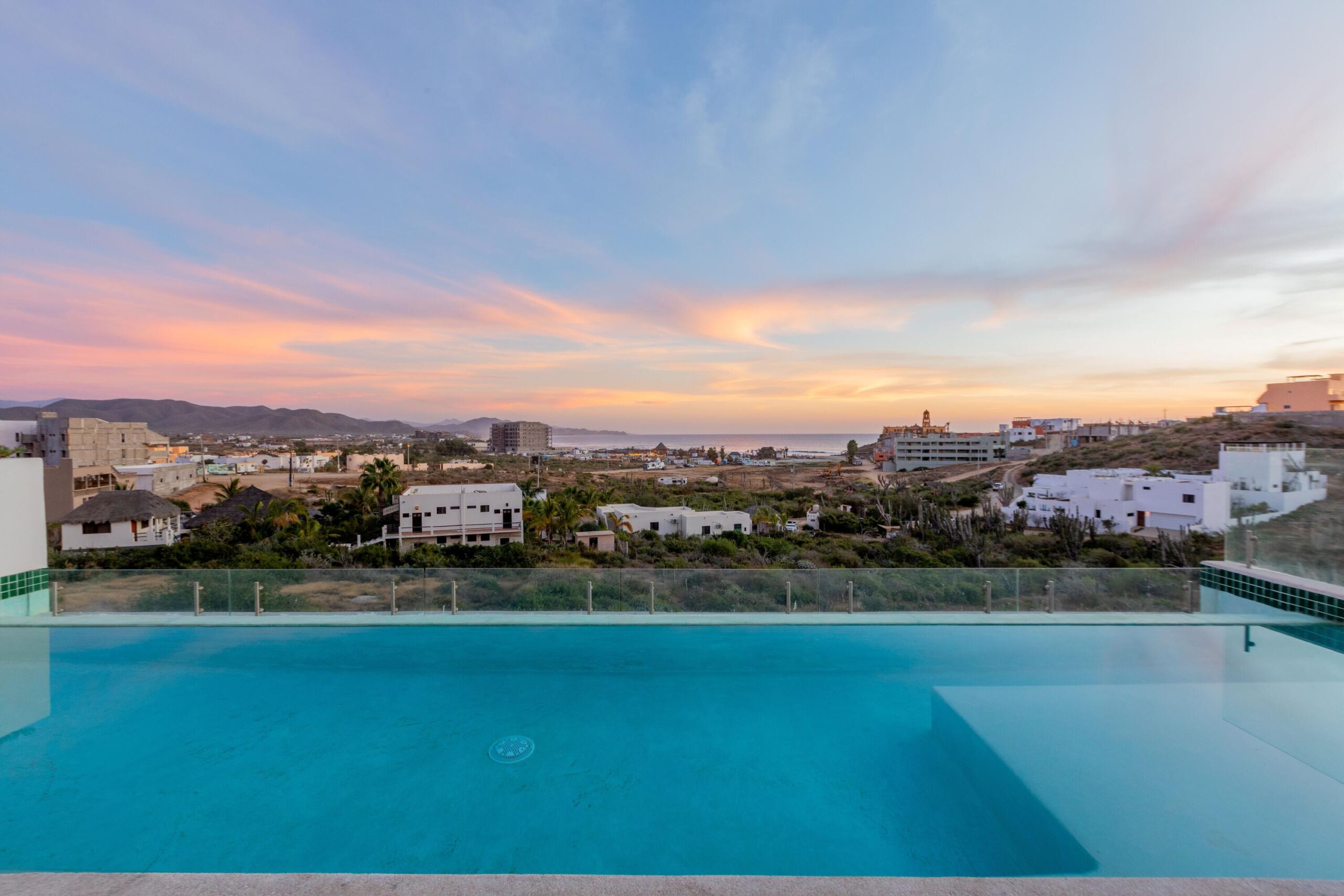 Los Cabos Morgan Residences Morgan Residences Condo 306 offers 67 m² of functional living space with one bedroom, one and a half baths, and a private balcony overlooking the city. The open floor plan connects the kitchen, dining, and living areas with marble-style tile throughout. The kitchen has granite counters, white cabinets, and an island with seating. The bedroom includes an ensuite bathroom with a walk-in shower and opens to the terrace. A separate half bath includes in-unit laundry. The building features a rooftop pool, gym, BBQ area, and for sale